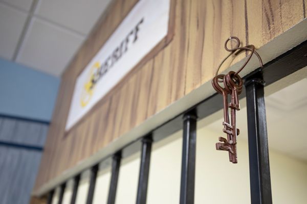 Old keys hanging on a wooden ledge.