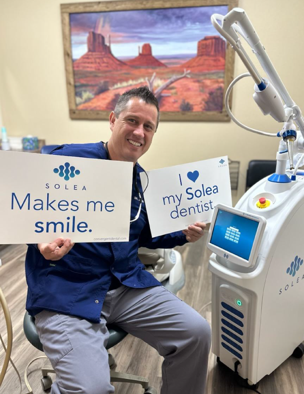 Person holding dentist signs with dental equipment.